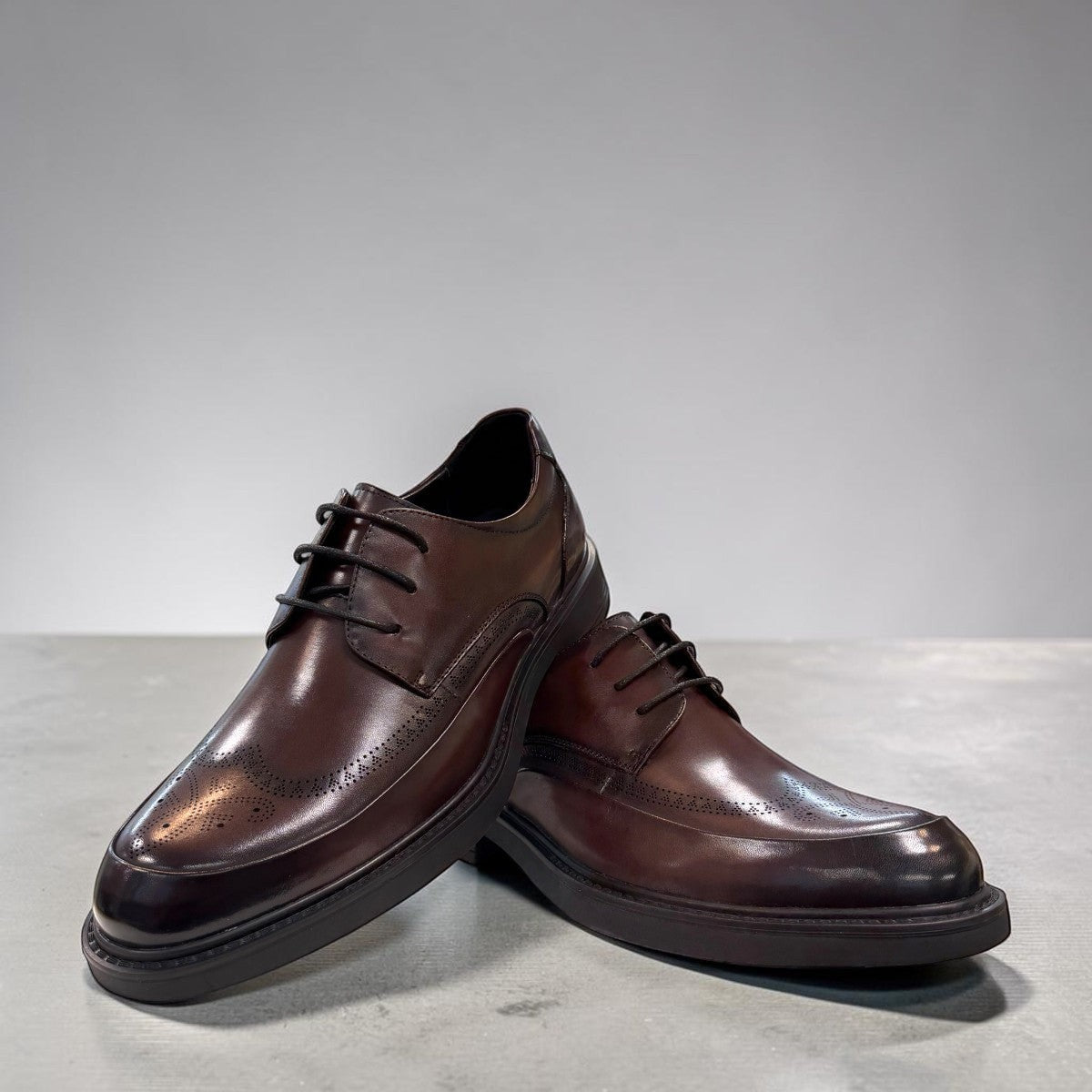 Sina Footwear dark brown leather derby shoe with brogue-inspired perforated details and a lightweight chunky sole.
 photo of the front side