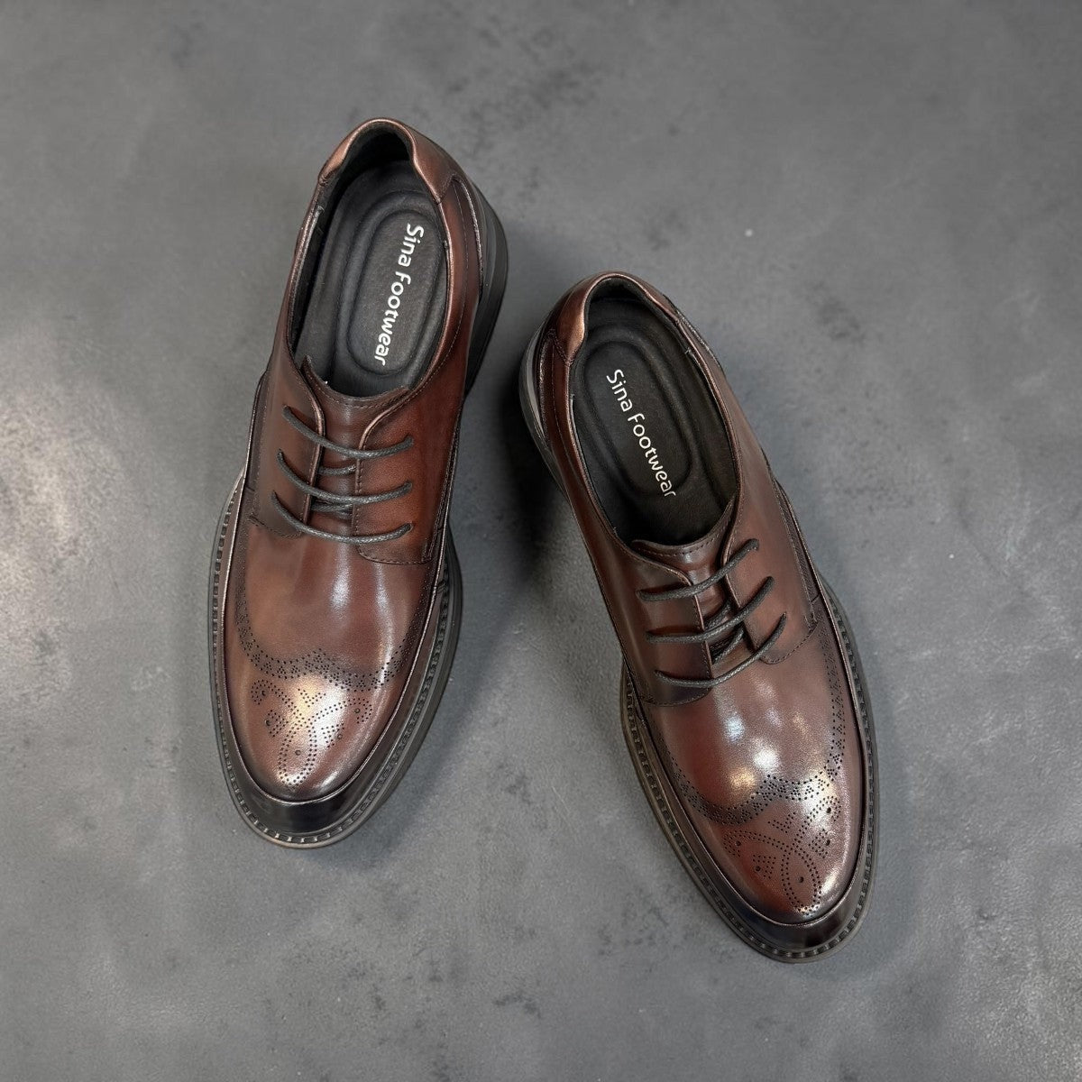 Sina Footwear dark brown leather derby shoe with brogue-inspired perforated details and a lightweight chunky sole.
 photo of the top side