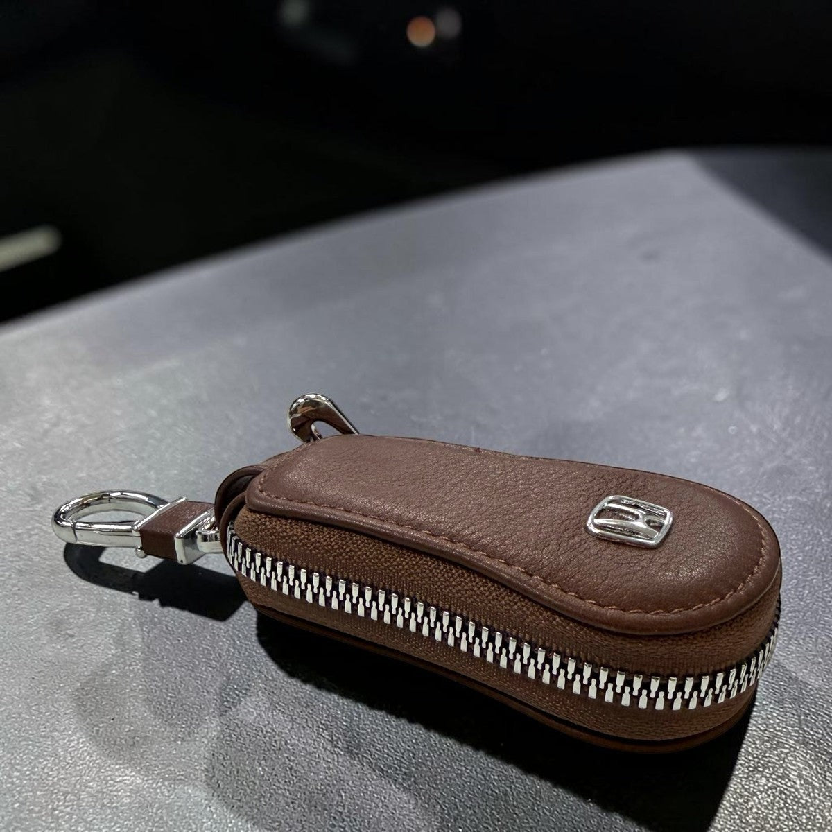 Sina Footwear dark brown leather key holder wallet with silver zipper and metal clip. Compact and stylish for everyday use.