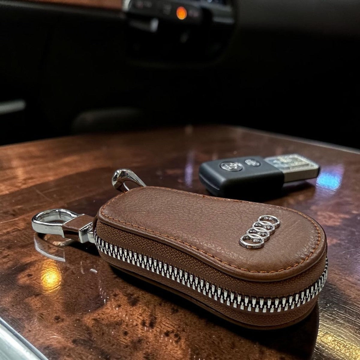 Sina Footwear dark brown leather key holder wallet with zipper closure and metal clip. Features Audi logo.
