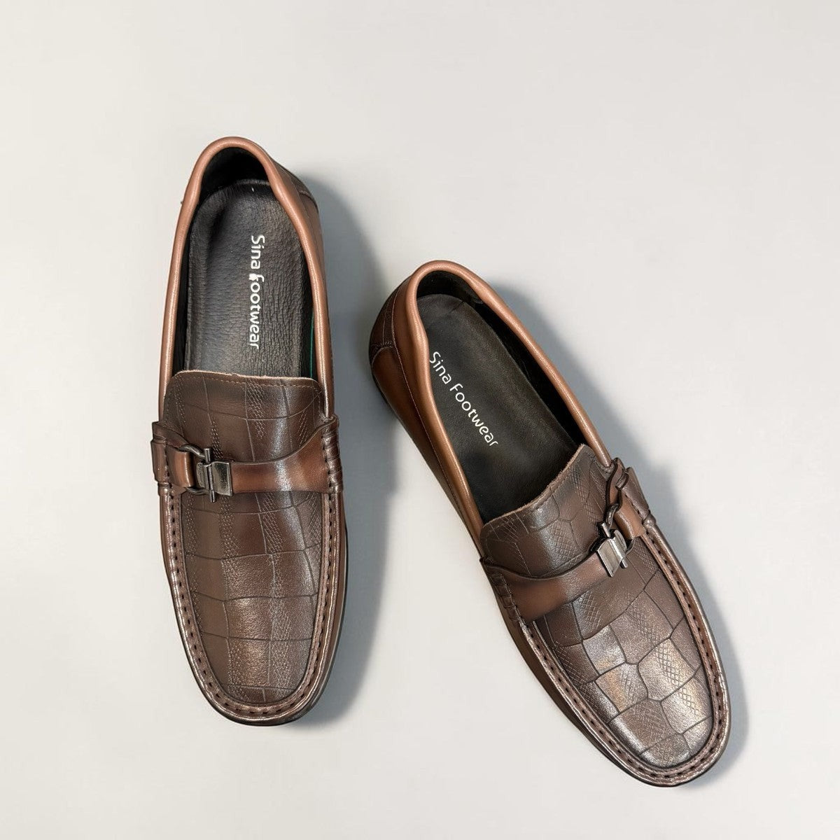 Sina Footwear dark brown genuine leather loafer with crocodile-embossed detail and a durable rubber outsole.
photo of the top side