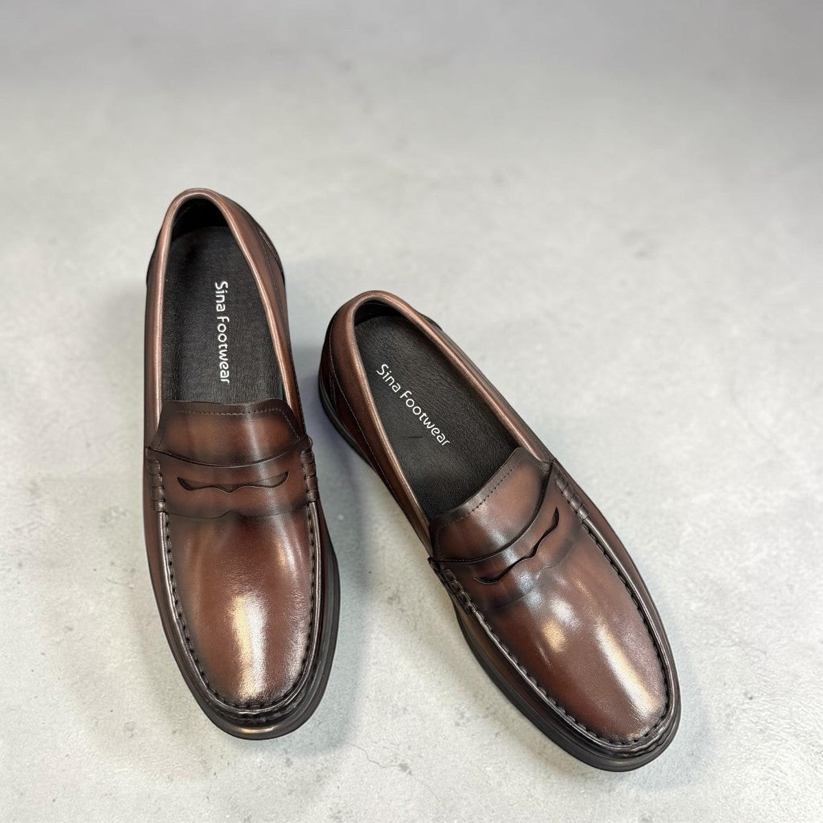 Sina Footwear dark brown genuine leather penny loafer with a classic silhouette and durable rubber outsole.
photo of the top side
