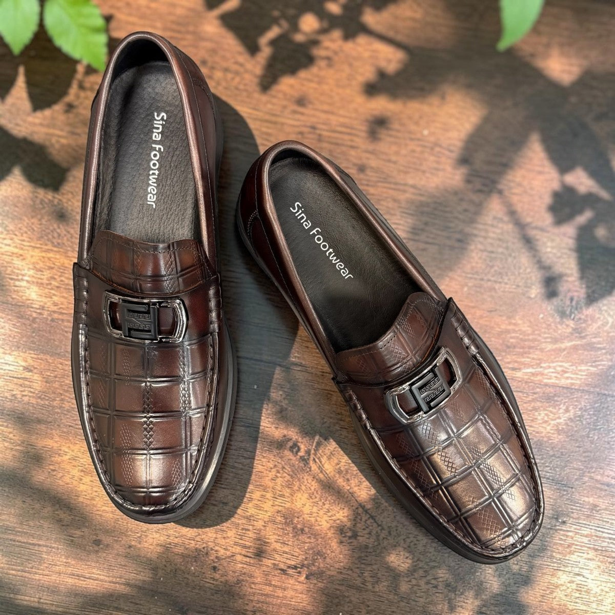 Sina Footwear dark brown genuine leather loafer with a textured croc-effect vamp and metallic buckle detail.
 photo of the top side
