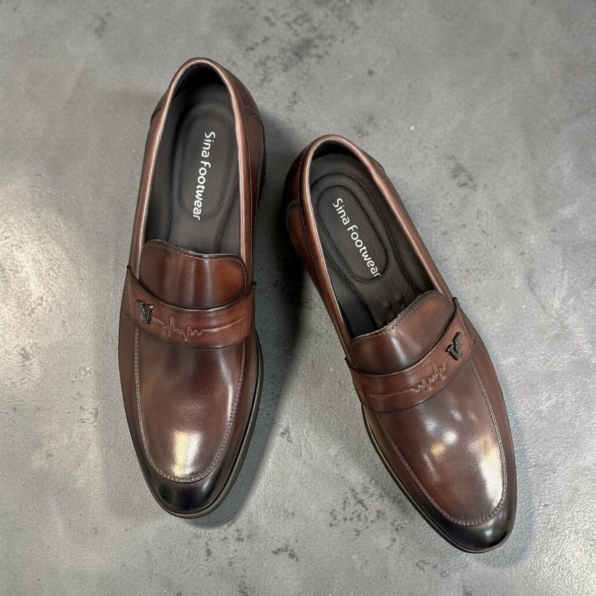 Sina Footwear dark brown genuine leather loafer with a classic silhouette, metal detail, and durable rubber outsole.
photo of the top side