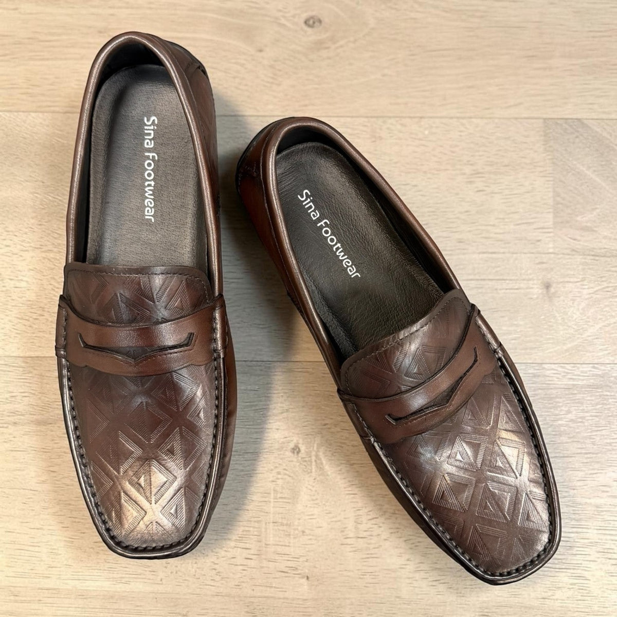 Sina Footwear dark brown genuine leather loafer with embossed geometric pattern and durable rubber outsole.
photo of the top side