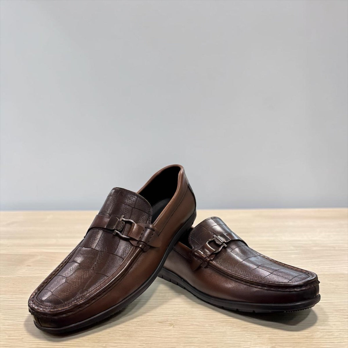 Sina Footwear dark brown genuine leather loafer with crocodile-embossed detail and a durable rubber outsole.
photo of the front side