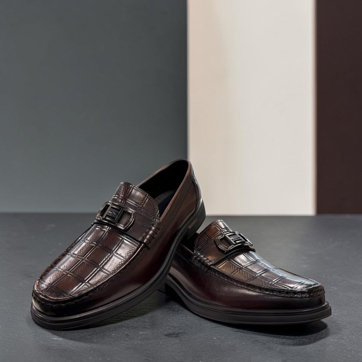 Sina Footwear dark brown genuine leather loafer with a textured croc-effect vamp and metallic buckle detail.
 photo of the front side