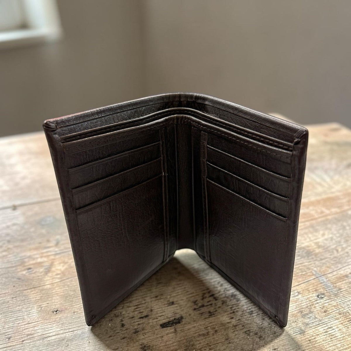 Sina Footwear dark brown genuine leather bi-fold wallet with multiple card slots and inner compartments.