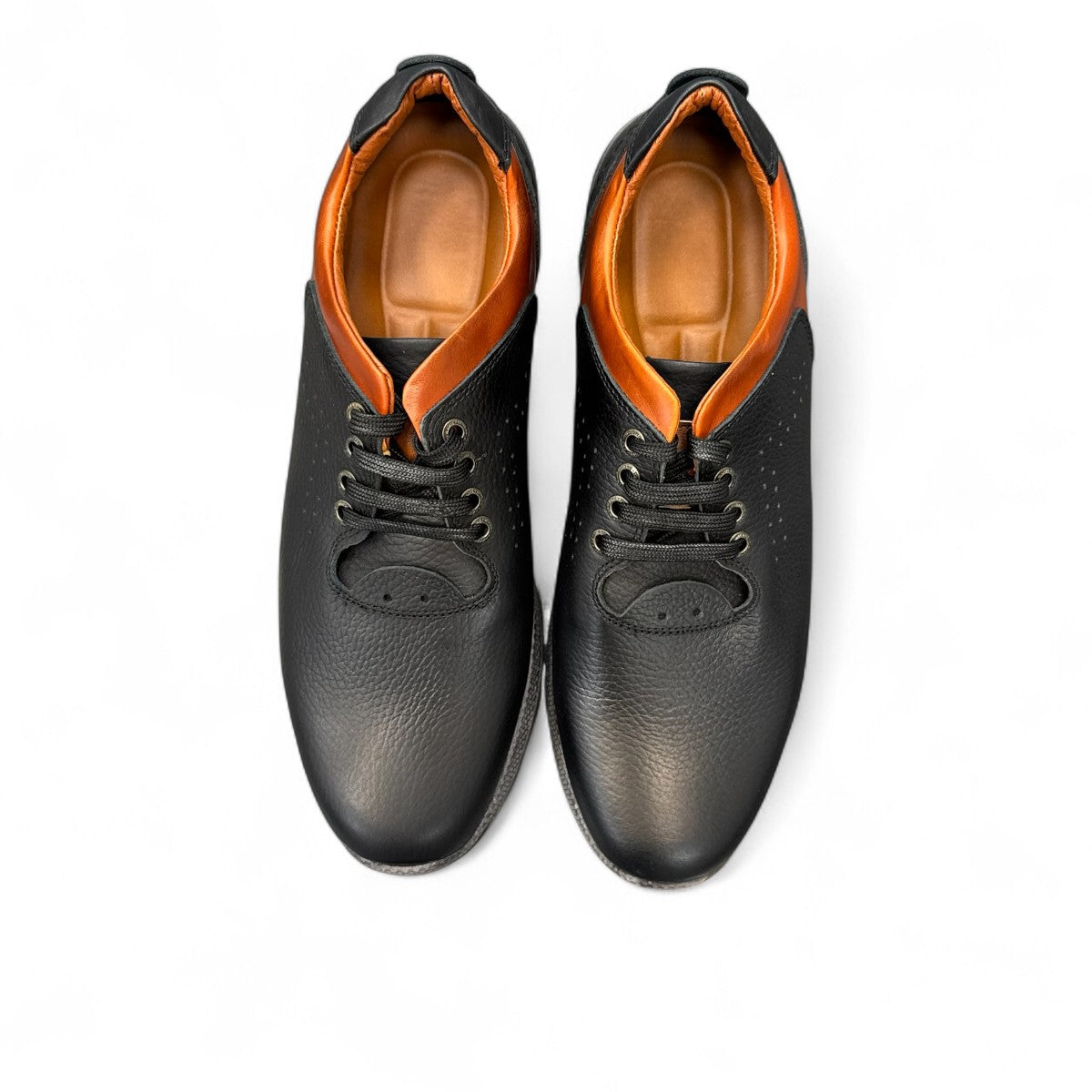 Sina Footwear Gilan black leather lace-up shoe with brown heel detail, textured rubber outsole, and side stitching. Photo of the soles.