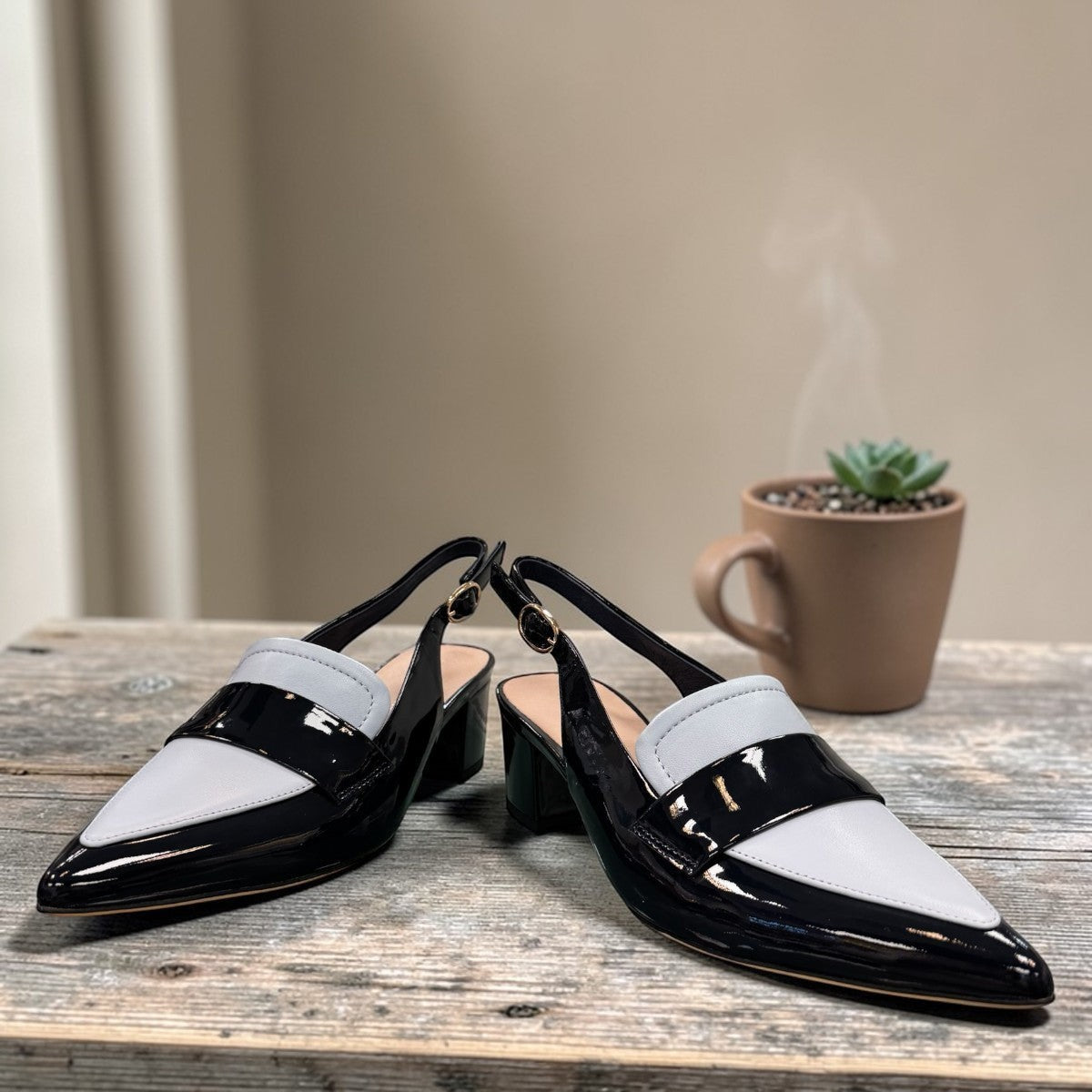 Django & Juliette navy patent leather slingback loafers with a 2-inch block heel and adjustable strap.
front view.