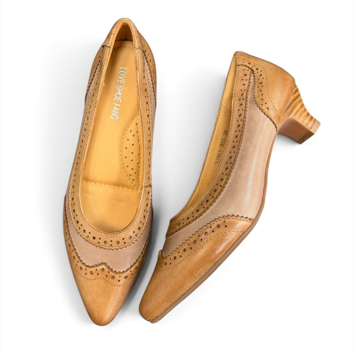 Sina Footwear tan leather pump with pointed toe, brogue-inspired perforated details, and a low block heel.
photo of the top side