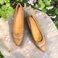 Sina Footwear tan leather pump with pointed toe, brogue-inspired perforated details, and a low block heel.
photo of the top side
