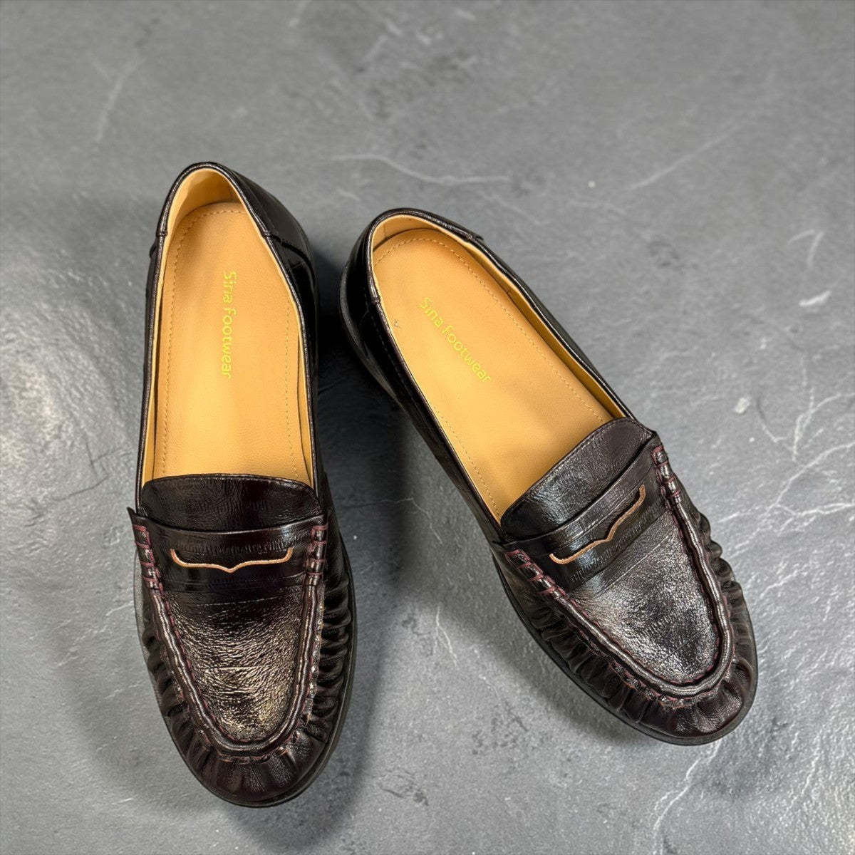 Sina Footwear wine-colored genuine leather loafer with hand-finished gathered detailing and a durable rubber outsole.
photo of the top side