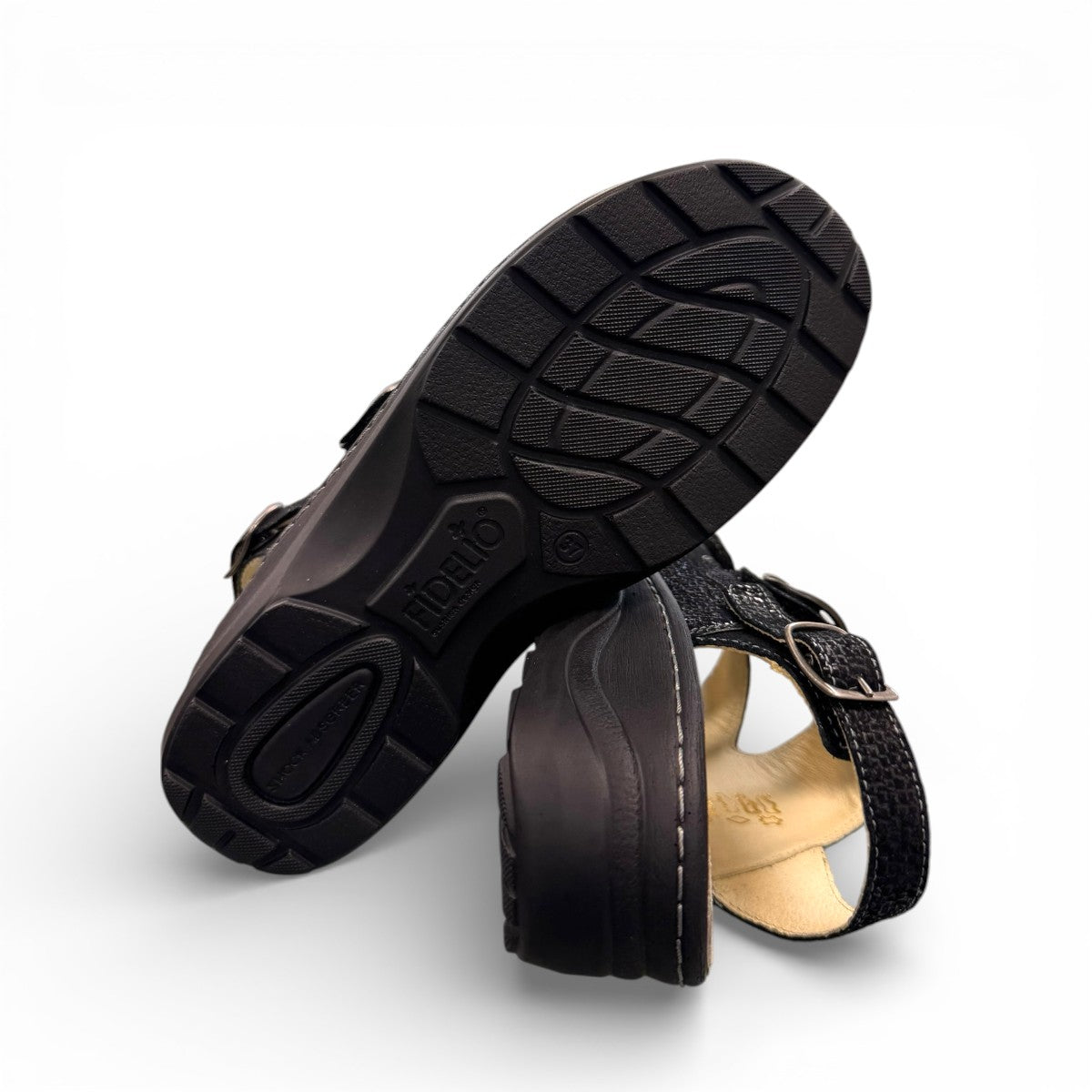 softline black leather Hedi wedge sandals with shiny finish, adjustable velcro straps, and decorative buckle.
photo of the bottom side