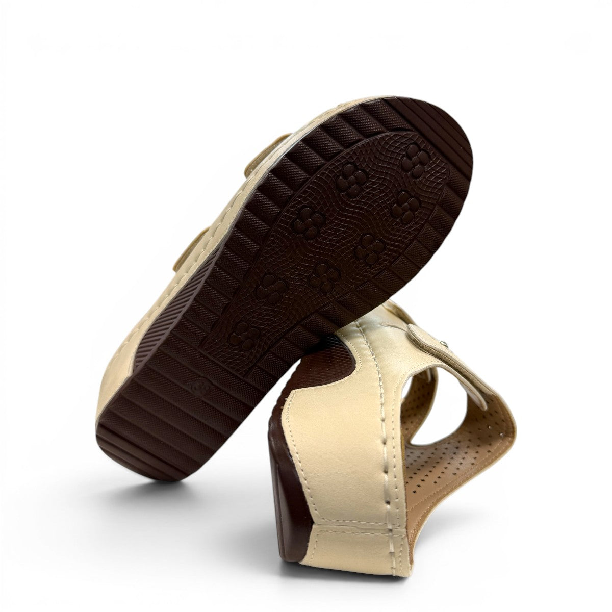 sole-flex-S1110 beige comfort slide sandals with adjustable straps, cut-out floral details, and a low wedge platform.
photo of the bottom side