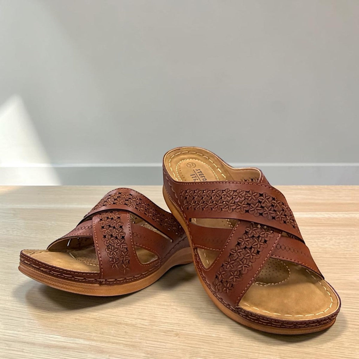 stefania camel vegan leather slide sandal with floral laser-cut details and a comfortable cushioned sole.
photo of the front side