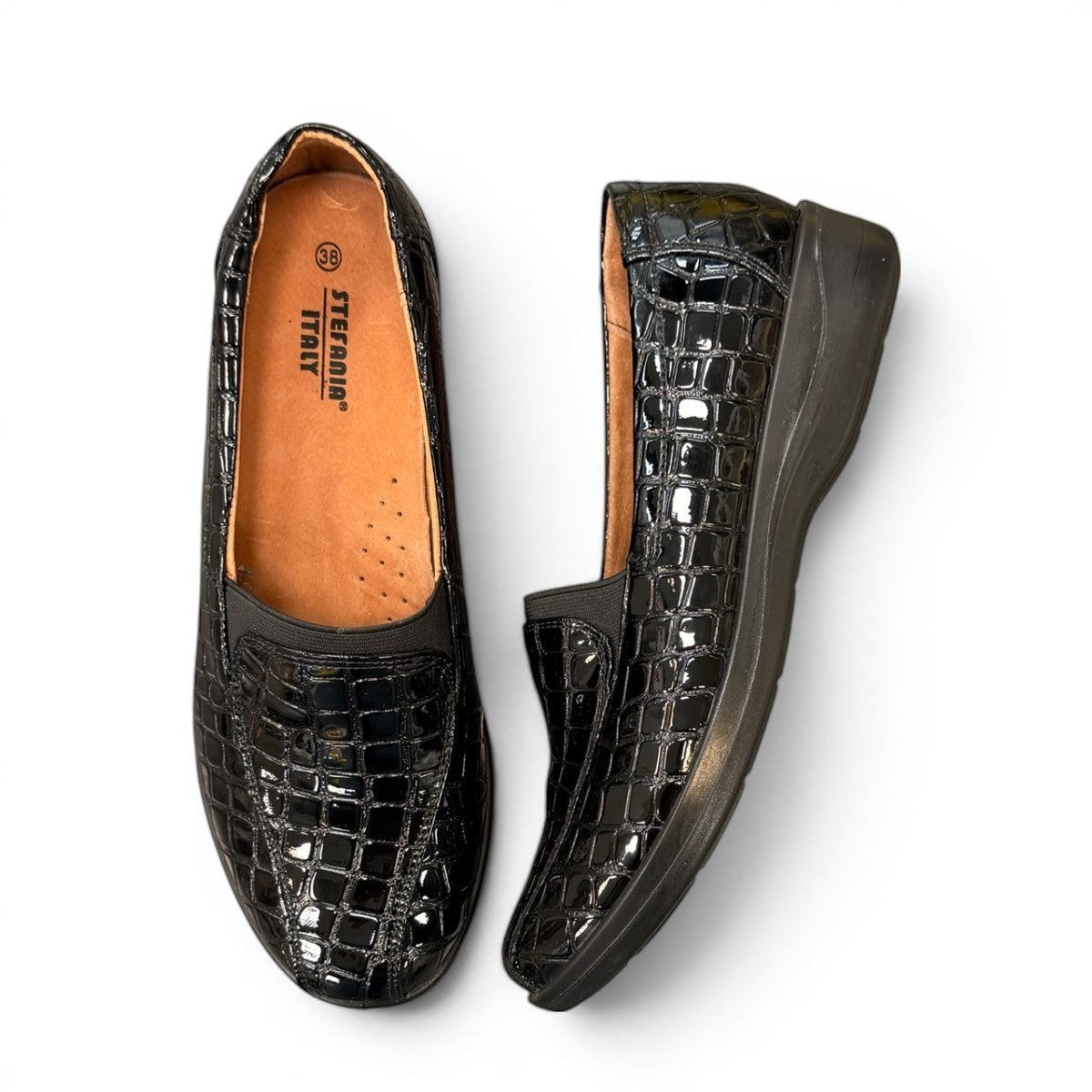 Stefania black croc-embossed slip-on shoe with a low wedge sole and elastic side panel for comfort.
photo of the top side