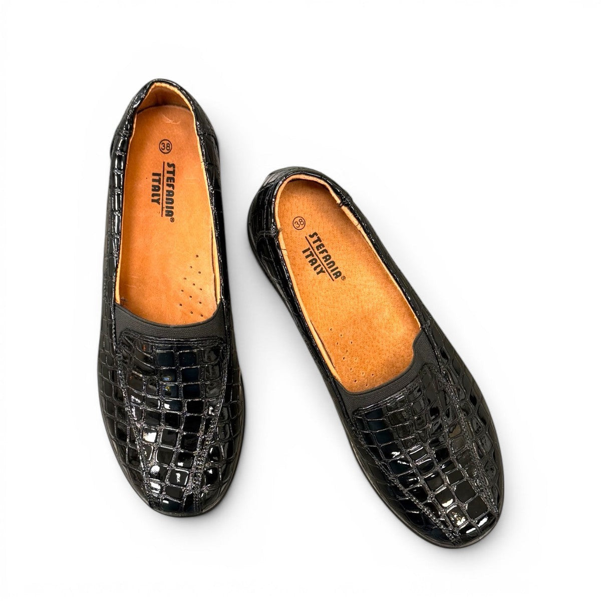 Stefania black croc-embossed slip-on shoe with a low wedge sole and elastic side panel for comfort.
photo of the top side