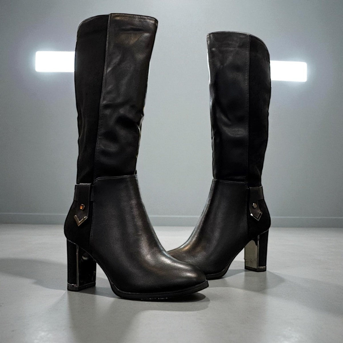 Stefania black vegan leather knee-high boots with fur lining, block heel, and metallic side detail.
photo of the front side