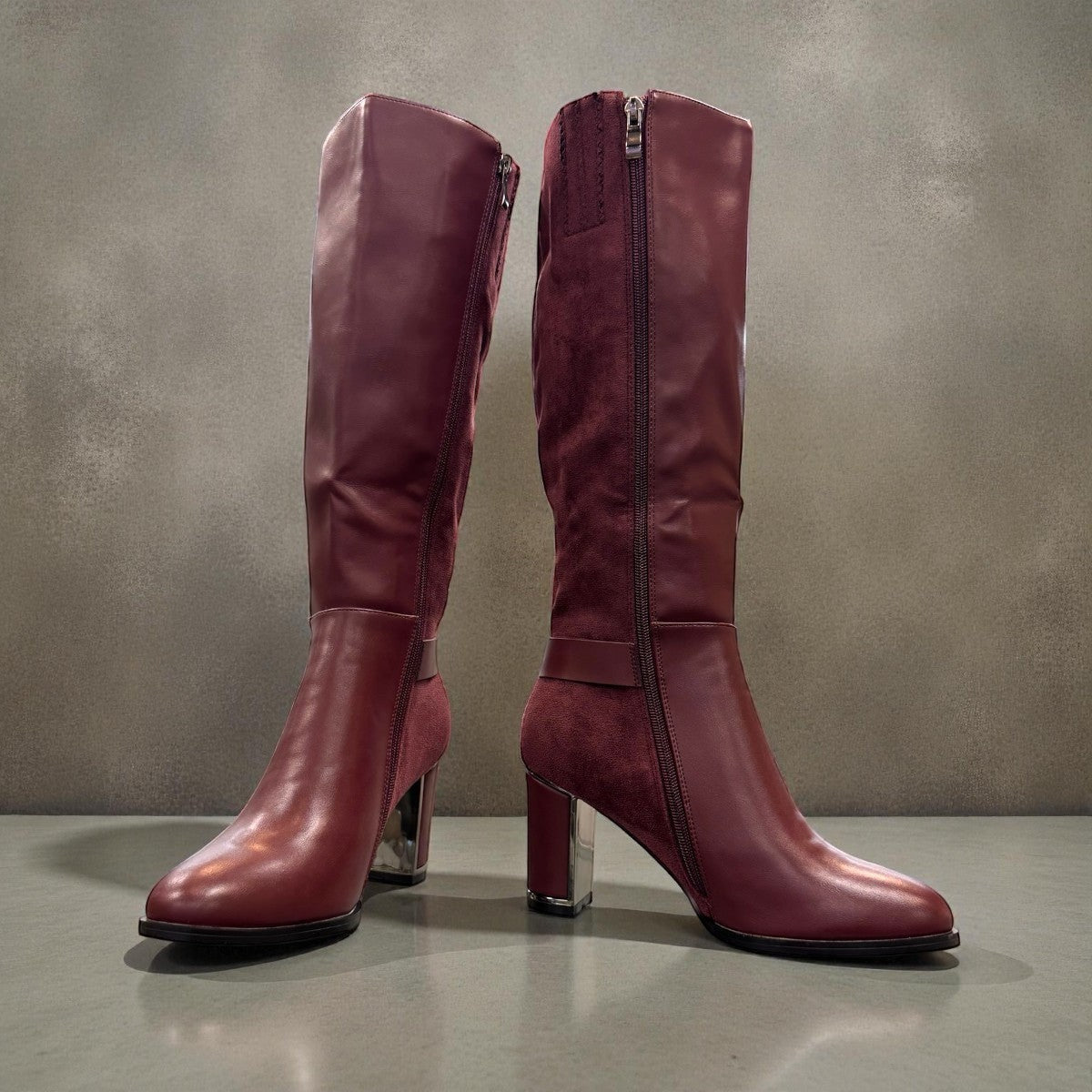 stefania bordo vegan leather knee-high boots with block heel, suede-like panels, and metallic side detail.
photo of the front side