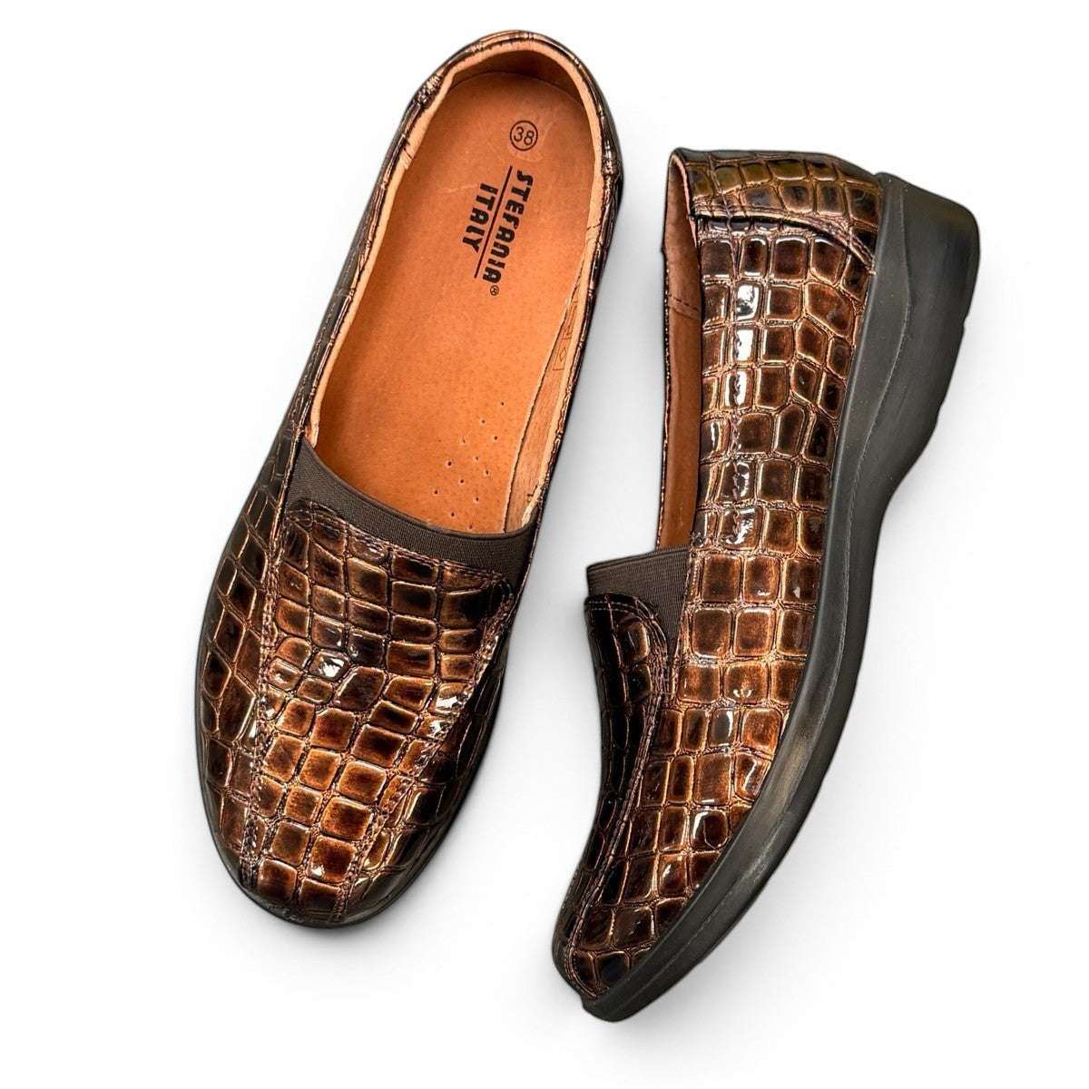 Stefania bronze croc-embossed slip-on shoe with a low wedge sole and elastic side panel.
photo of the top side