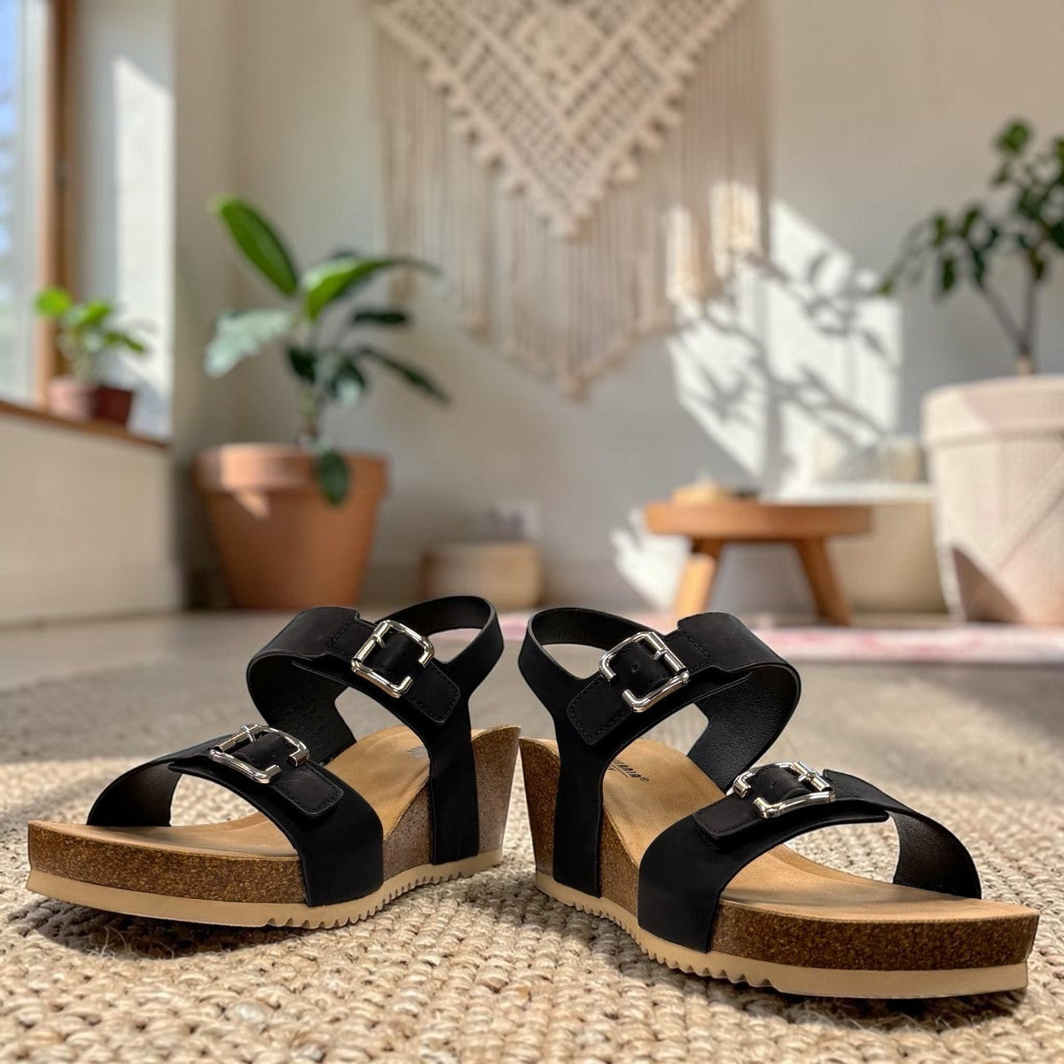 stefania dalia black double-strap wedge sandals with adjustable buckles, cushioned footbed, and cork-style platform sole.
photo of the front side