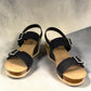 stefania dalia black double-strap wedge sandals with adjustable buckles, cushioned footbed, and cork-style platform sole.
photo of the front side