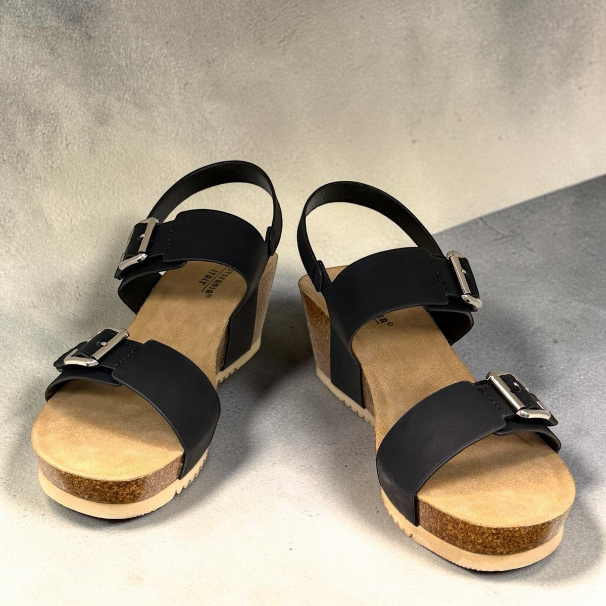 stefania dalia black double-strap wedge sandals with adjustable buckles, cushioned footbed, and cork-style platform sole.
photo of the front side