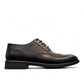 Sun Hesamak black leather lace-up dress shoe with brogue detailing and a durable rubber outsole. Photo of left side view.