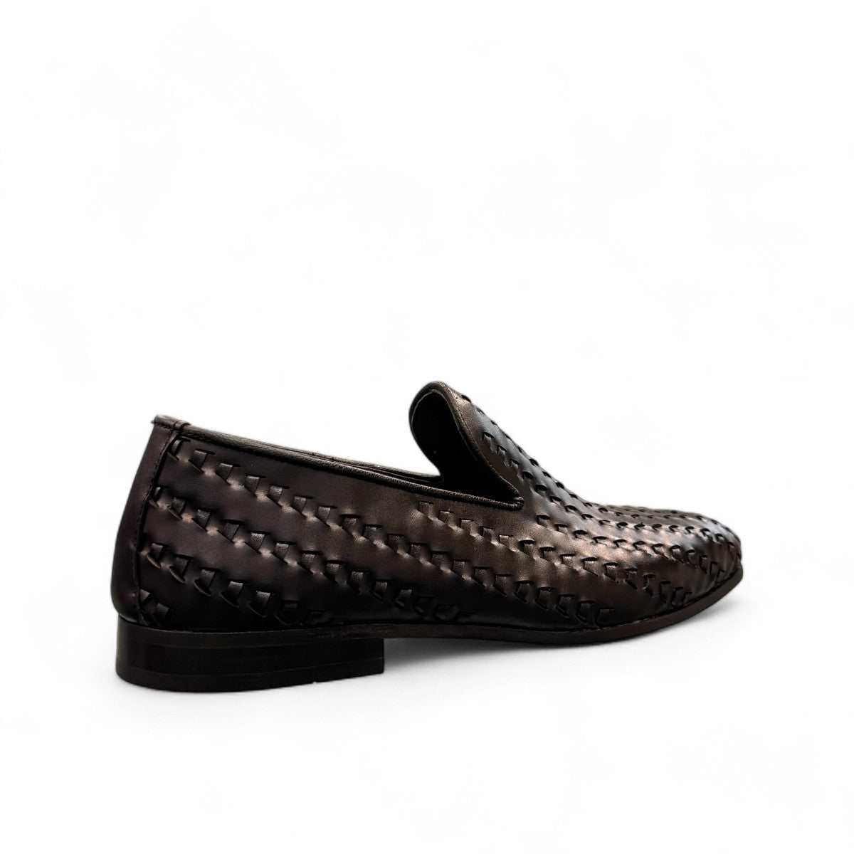 Sun Roniya black leather loafers featuring intricate handmade woven detailing and a rubber outsole. Photo of back view from a side angle.
