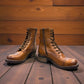 Taos Crave classic camel leather lace-up boot with side buckle and block heel. Photo of side view from the front.