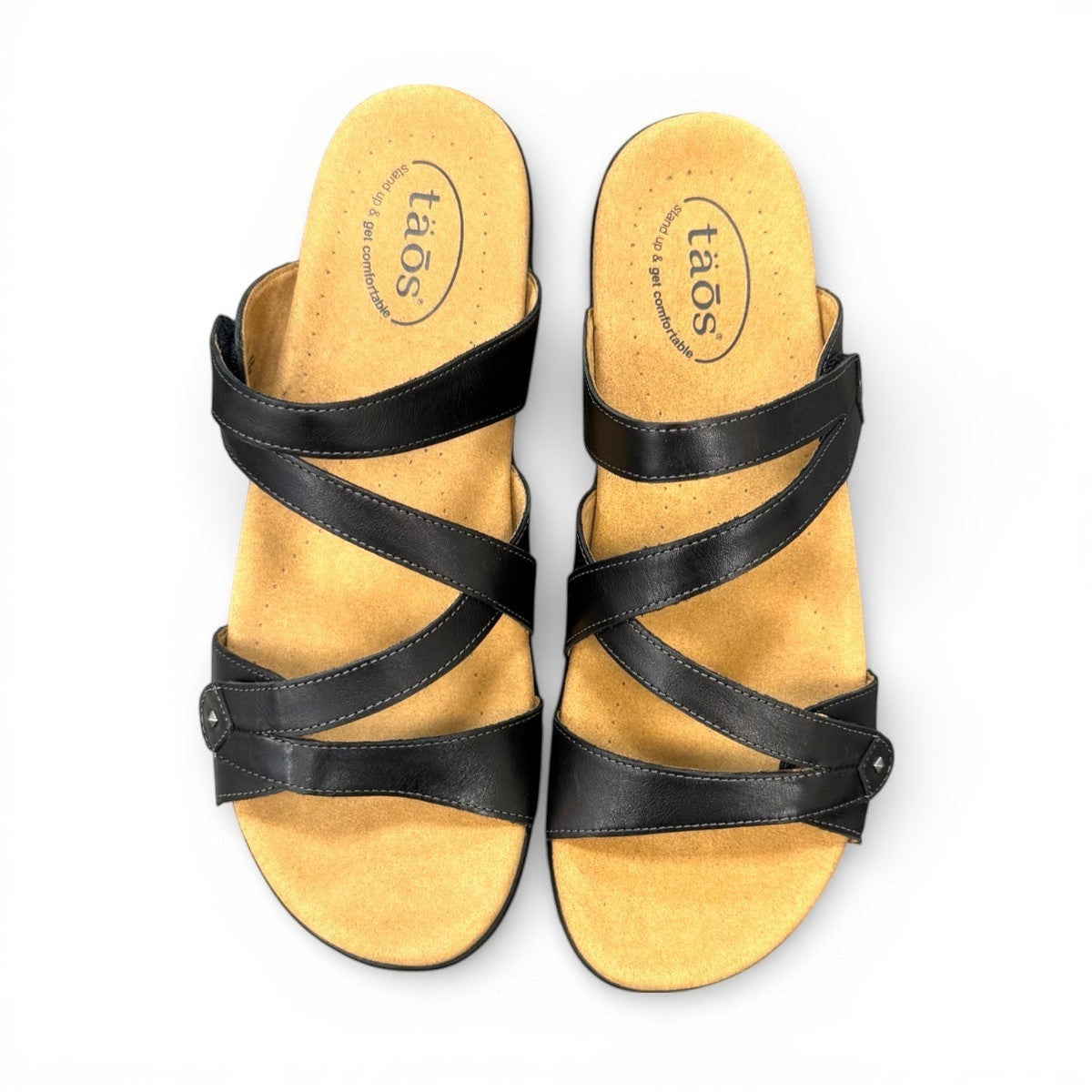 Taos Double U black leather slide sandal with adjustable hook and loop straps and cushioned foot bed. Photo of upper view.