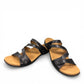 Taos Double U black leather slide sandal with adjustable hook and loop straps and cushioned foot bed. Photo of front view.