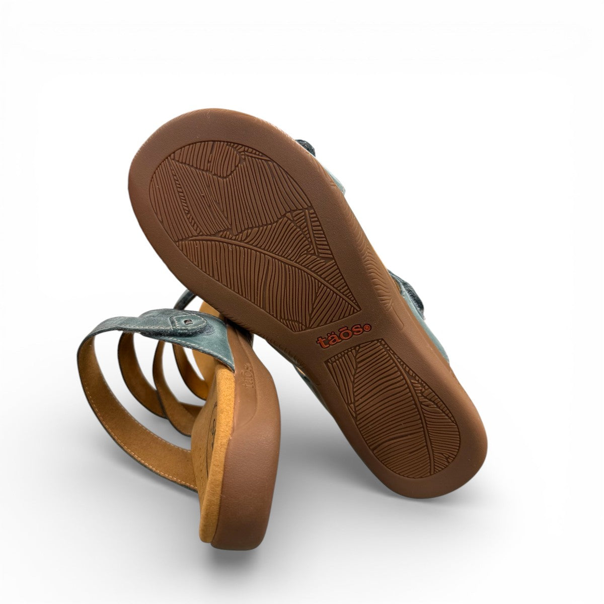Taos Double U teal leather slide sandals with adjustable hook and loop straps and cushioned footbed. Photo of bottom view.