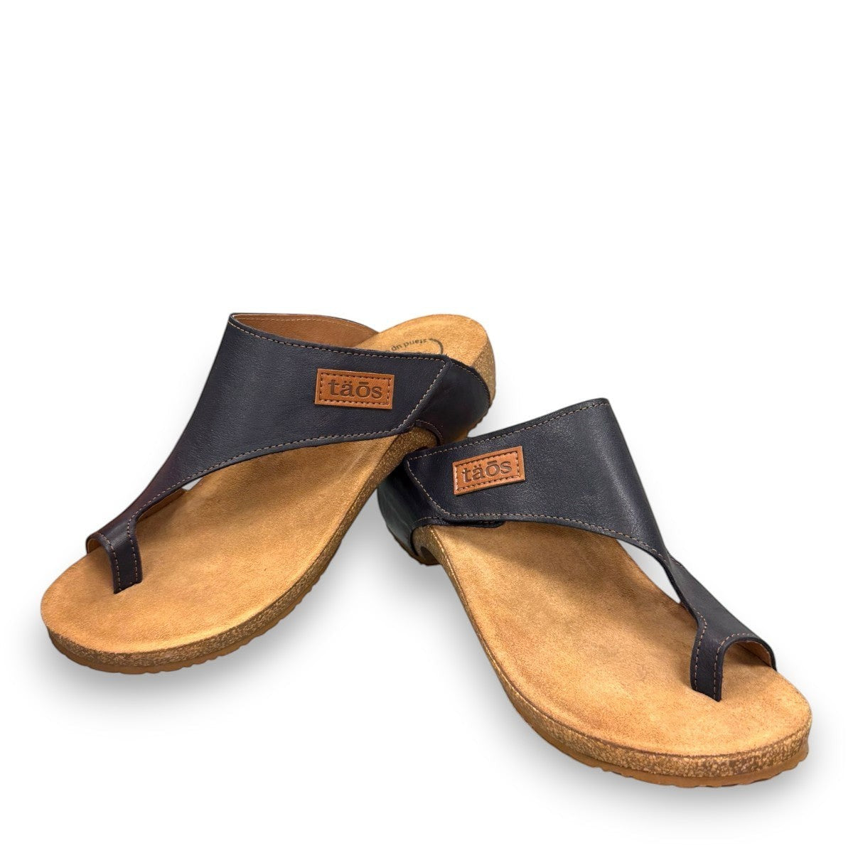 Taos Loop navy leather toe-post sandal with adjustable hook-and-loop strap and cushioned cork foot bed. Photo of front view.