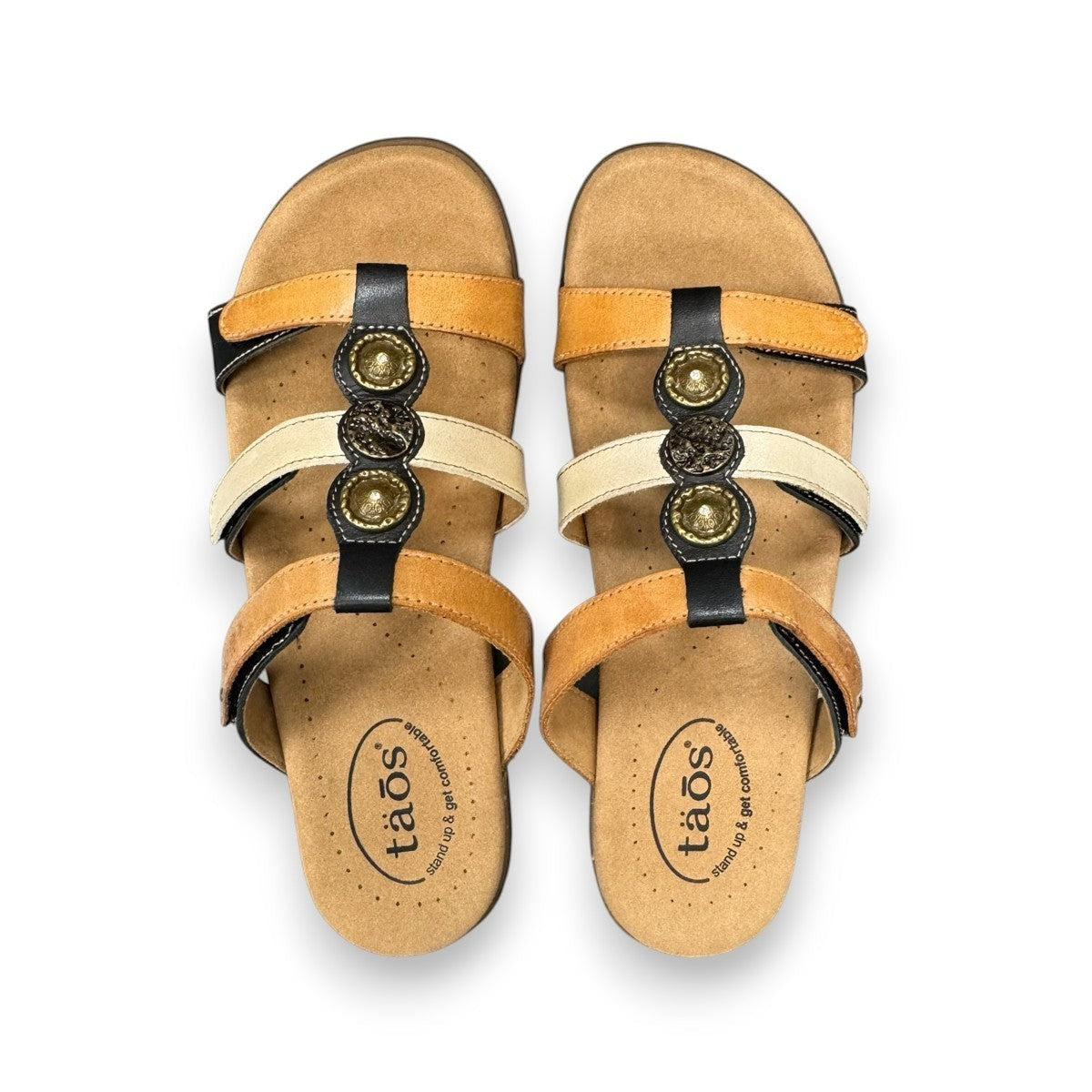 Taos Prize 4 tan multi leather slide sandals with adjustable hook and loop straps and medallion hardware. Photo of upper view.