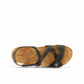 Taos Universe black leather sandal with Z-strap design, cork footbed, and metallic medallion accents. Photo of upper view.