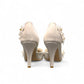 Ticky white pointed-toe high heel pump featuring delicate floral embellishments with crystal accents. Photo of back view.