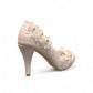 Ticky white pointed-toe high heel pump featuring delicate floral embellishments with crystal accents. Photo of back side view.