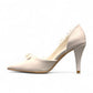 Ticky white pointed-toe high heel pump featuring delicate floral embellishments with crystal accents. Photo of left side view.
