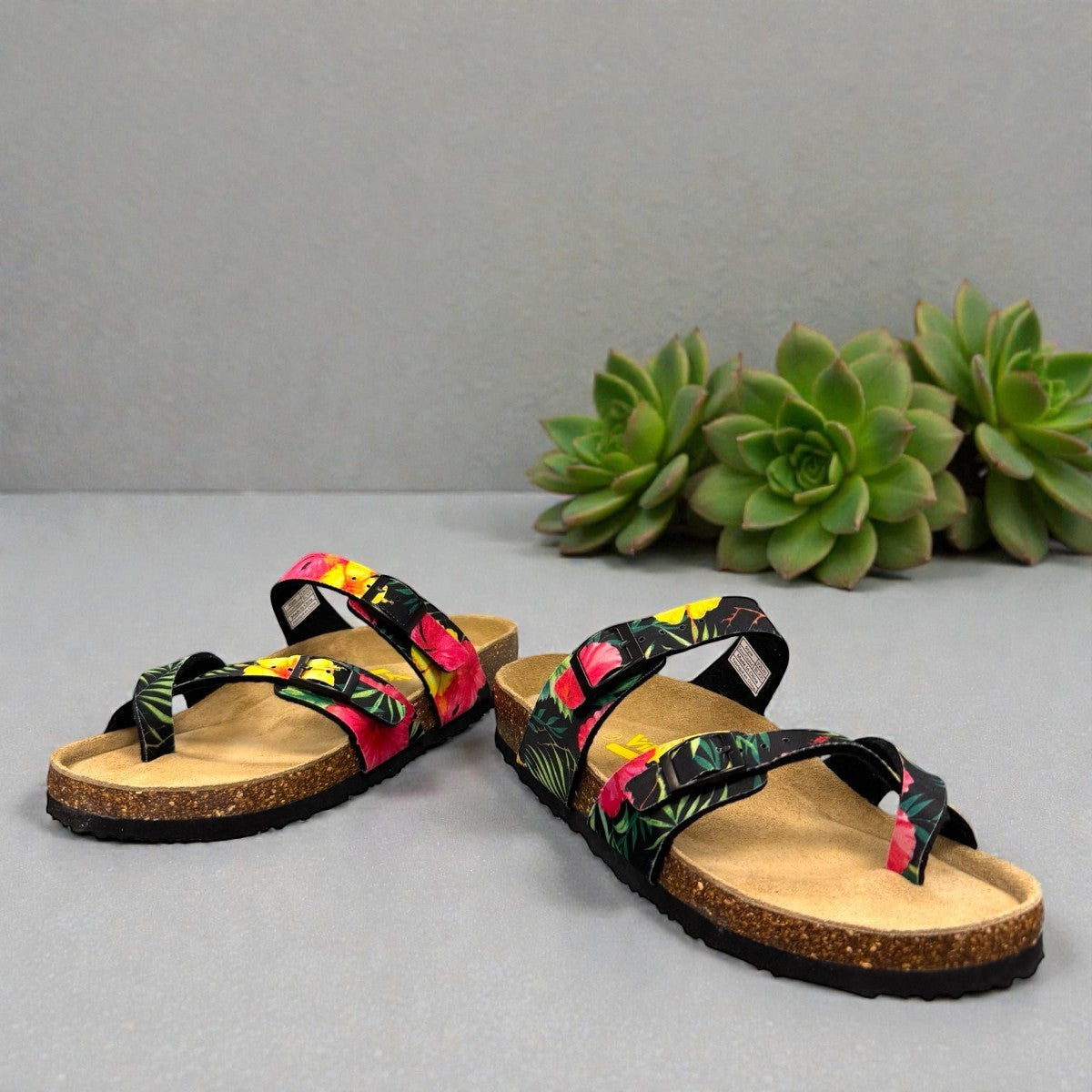 Vikings Tofino toe-loop sandals in black hibiscus floral print with adjustable buckles and cork midsole.
photo of the front side