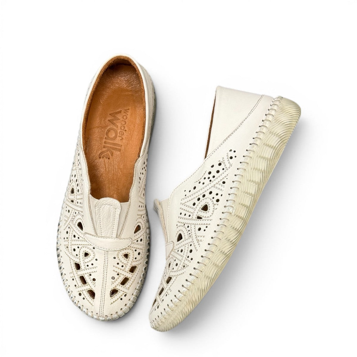 wonder-metadata-S5552 white leather slip-on shoe with intricate laser-cut patterns and a flexible cushioned sole.
photo of the top side
