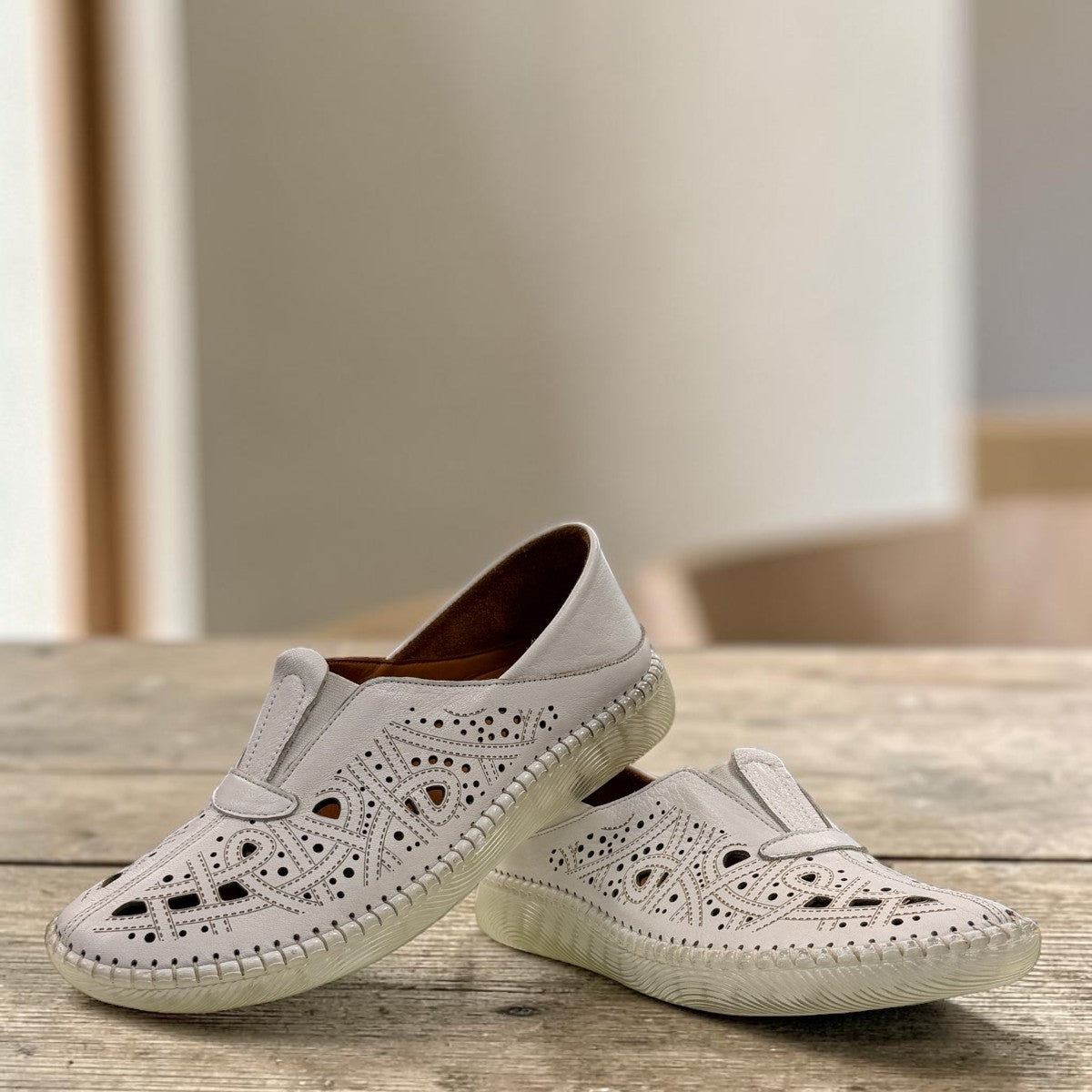 wonder-metadata-S5552 white leather slip-on shoe with intricate laser-cut patterns and a flexible cushioned sole.
photo of the front side