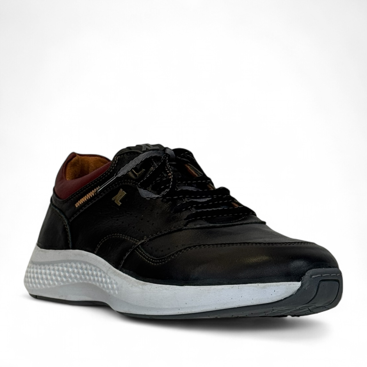 XL EVER LIFE HANNA black leather sneaker with a white textured sole and maroon heel detail. Photo of front side view.